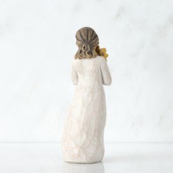 Side view of woman with tied back brown hair holding a cluster of yellow flowers to her face