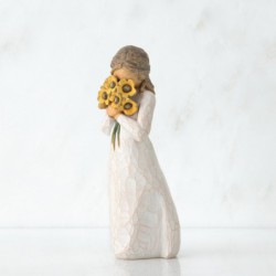 Side view of woman with tied back brown hair holding a cluster of yellow flowers to her face