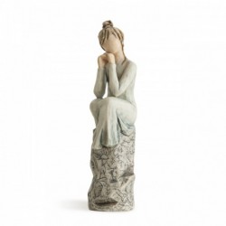 Brunette woman figurine sitting on grey rock