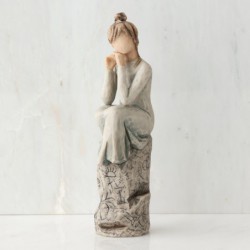 Brunette woman figurine sitting on grey rock