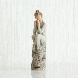 Brunette woman figurine sitting on grey rock