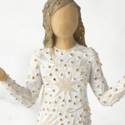 Front view of brunette girl figurine in white dress with gold dots holding her hands out