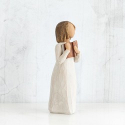 Faceless girl figurine wearing white dress holding brown book