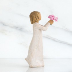Front side view of girl with light brown hair holding out pink flowers with both hands