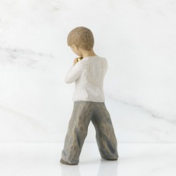Little boy figurine standing holding gold heart