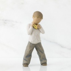 Little boy figurine standing holding gold heart