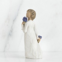 Brunette girl figurine in white dress holding two sets of blue flowers in each hand