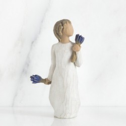 Brunette girl figurine in white dress holding two sets of blue flowers in each hand