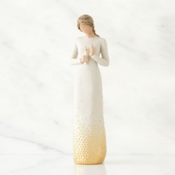 Faceless woman figurine wearing all white dress with her hands holding a candle