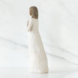 Brunette girl figurine in white dress holding white dove with one arm