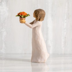 Front view: standing figure with short brown hair in cream dress holding out terracotta pot of orange milkweed plant