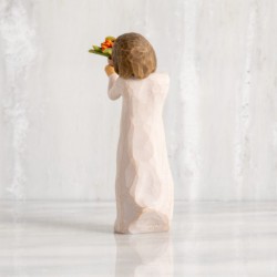 Front view: standing figure with short brown hair in cream dress holding out terracotta pot of orange milkweed plant