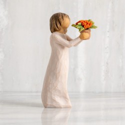 Front view: standing figure with short brown hair in cream dress holding out terracotta pot of orange milkweed plant