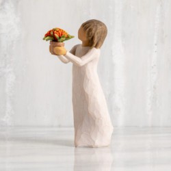 Front view: standing figure with short brown hair in cream dress holding out terracotta pot of orange milkweed plant