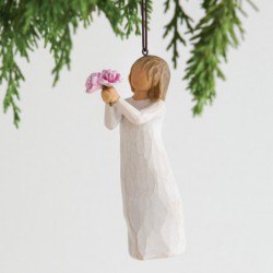 Front view of female figure in cream dress holding out small bouquet of pink peonies